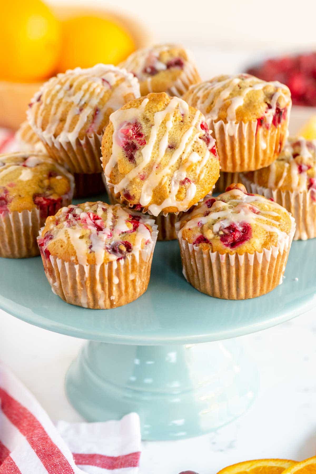Pile of cranberry orange muffins on a turquoise cake stand