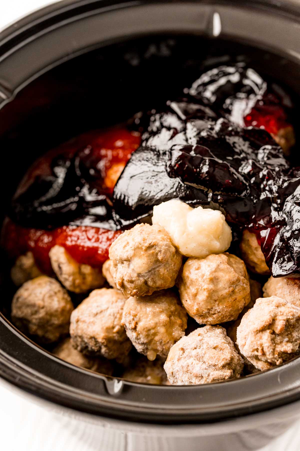 Frozen meatballs, grape jelly, and chili sauce in slow cooker