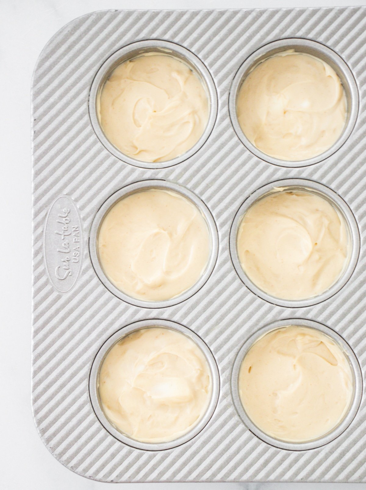 Oreo cheesecake filling in muffin tins