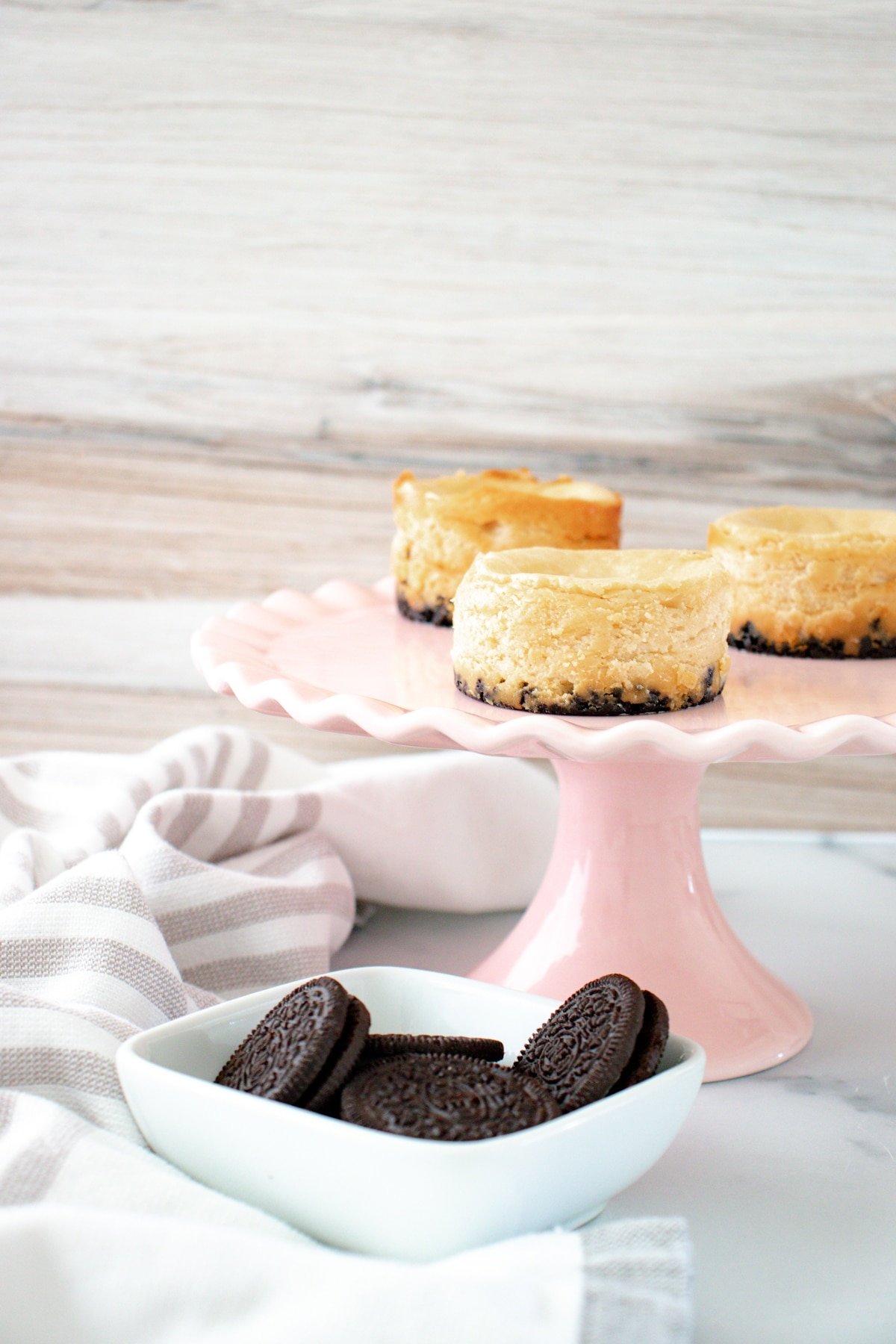 Pink cake stand with mini oreo cheesecakes on it