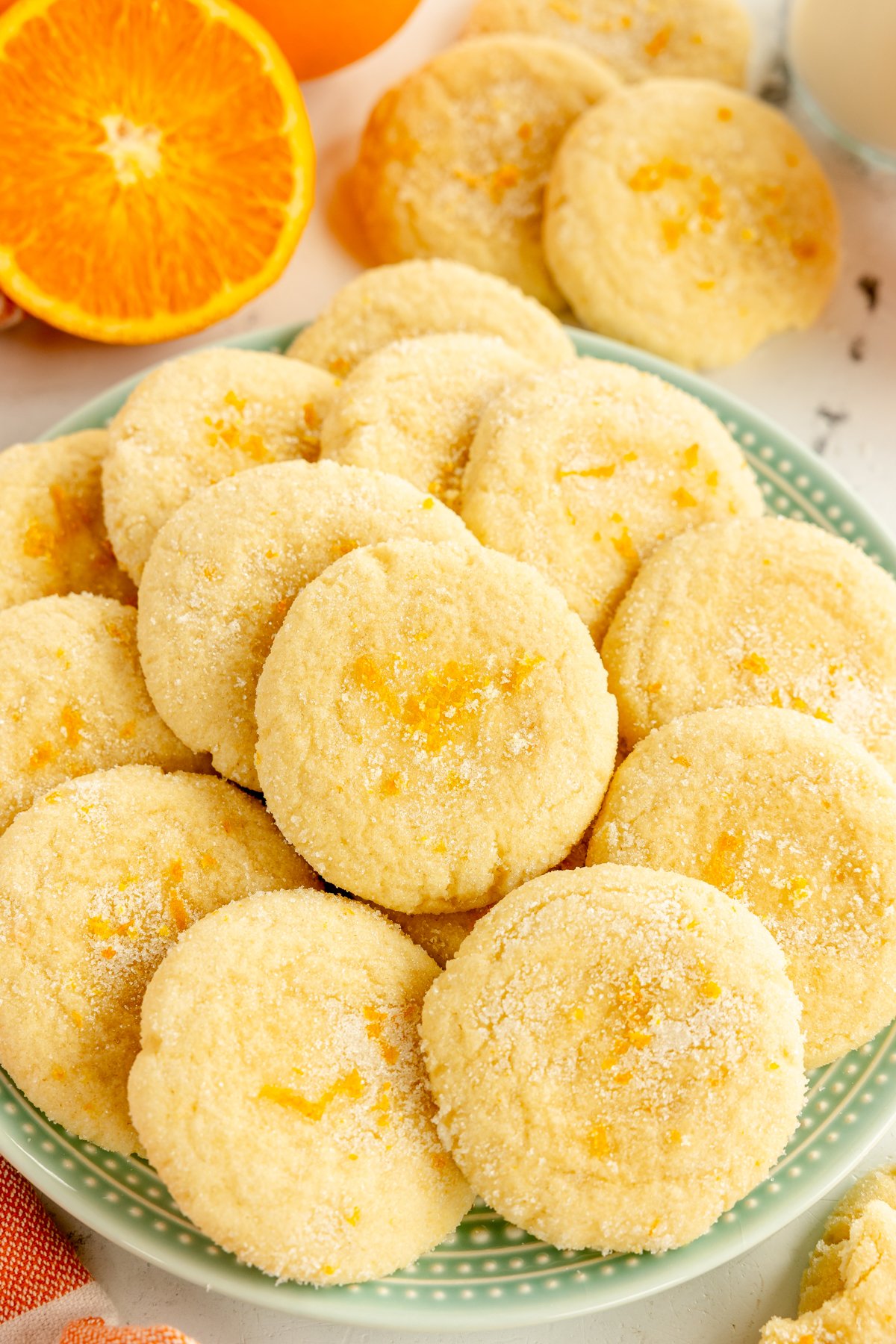 oranžiniai cukraus sausainiai žalsvai melsvoje lėkštėje