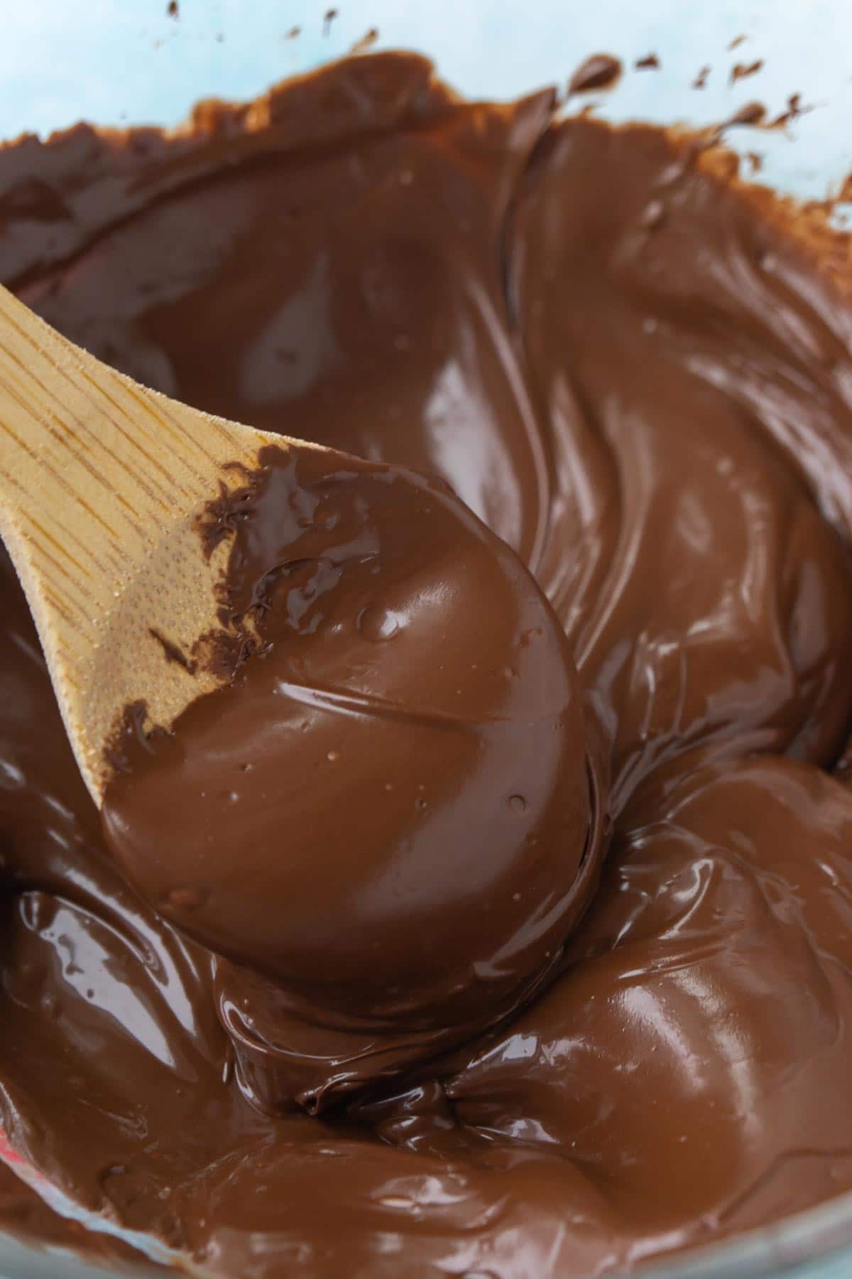 Wooden spoon in a bowl of melted chocolate