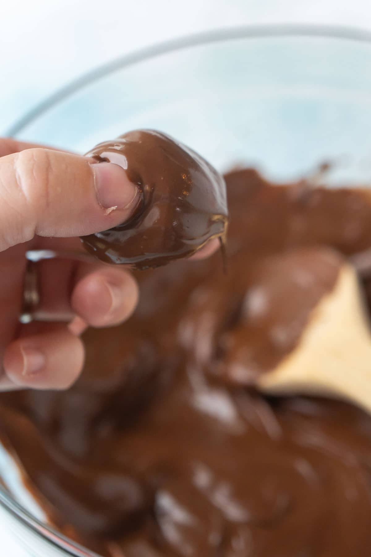 Woman's hand holding an Oreo truffle dipped in chocolate 