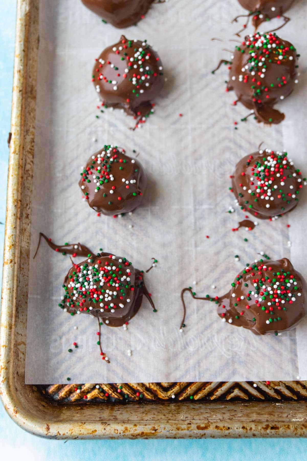Oreo truffles with Christmas sprinkles on a parchment paper