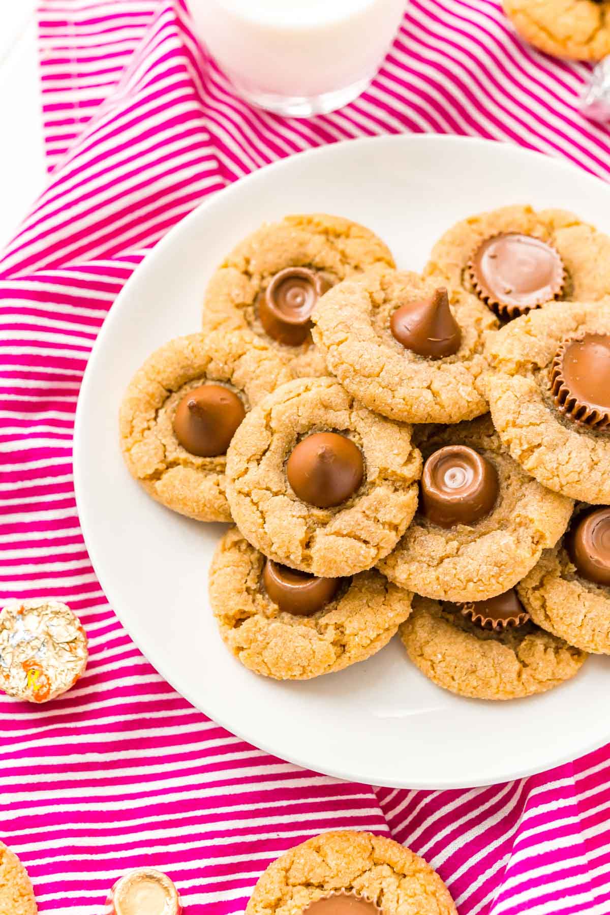 Plate full of peanut butter blossoms on a pink background