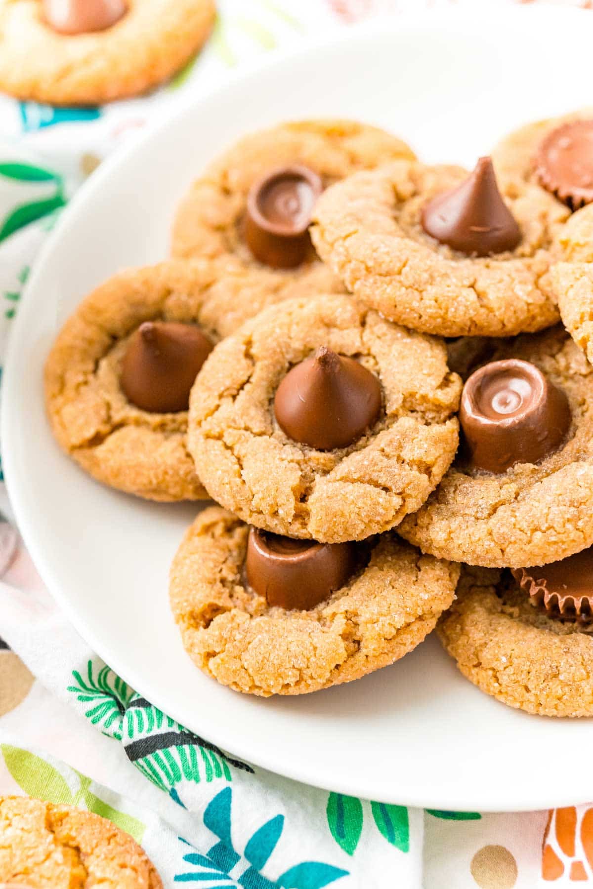 Plate full of peanut butter blossoms with a Christmas background