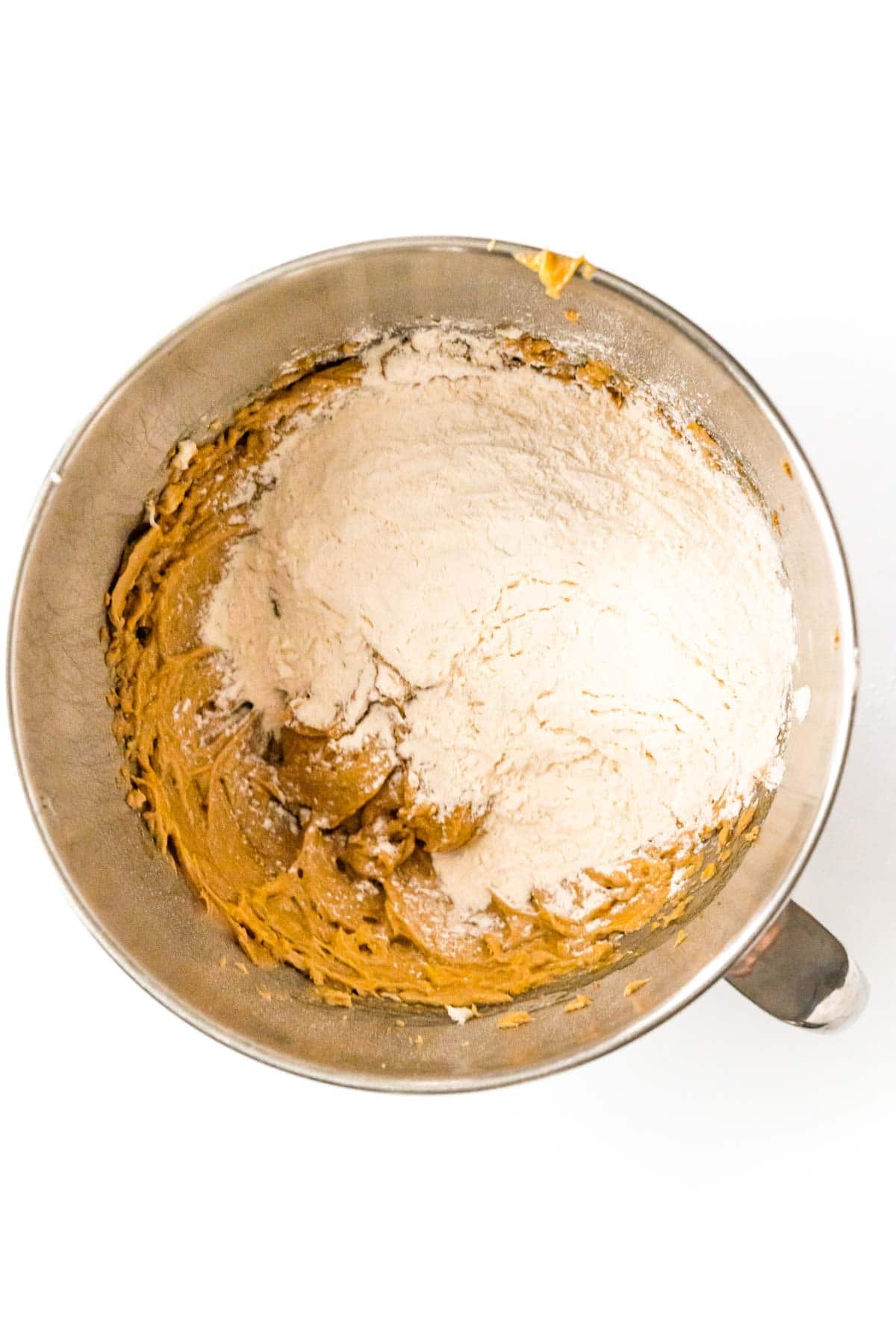 Flour and other ingredients in a metal mixing bowl