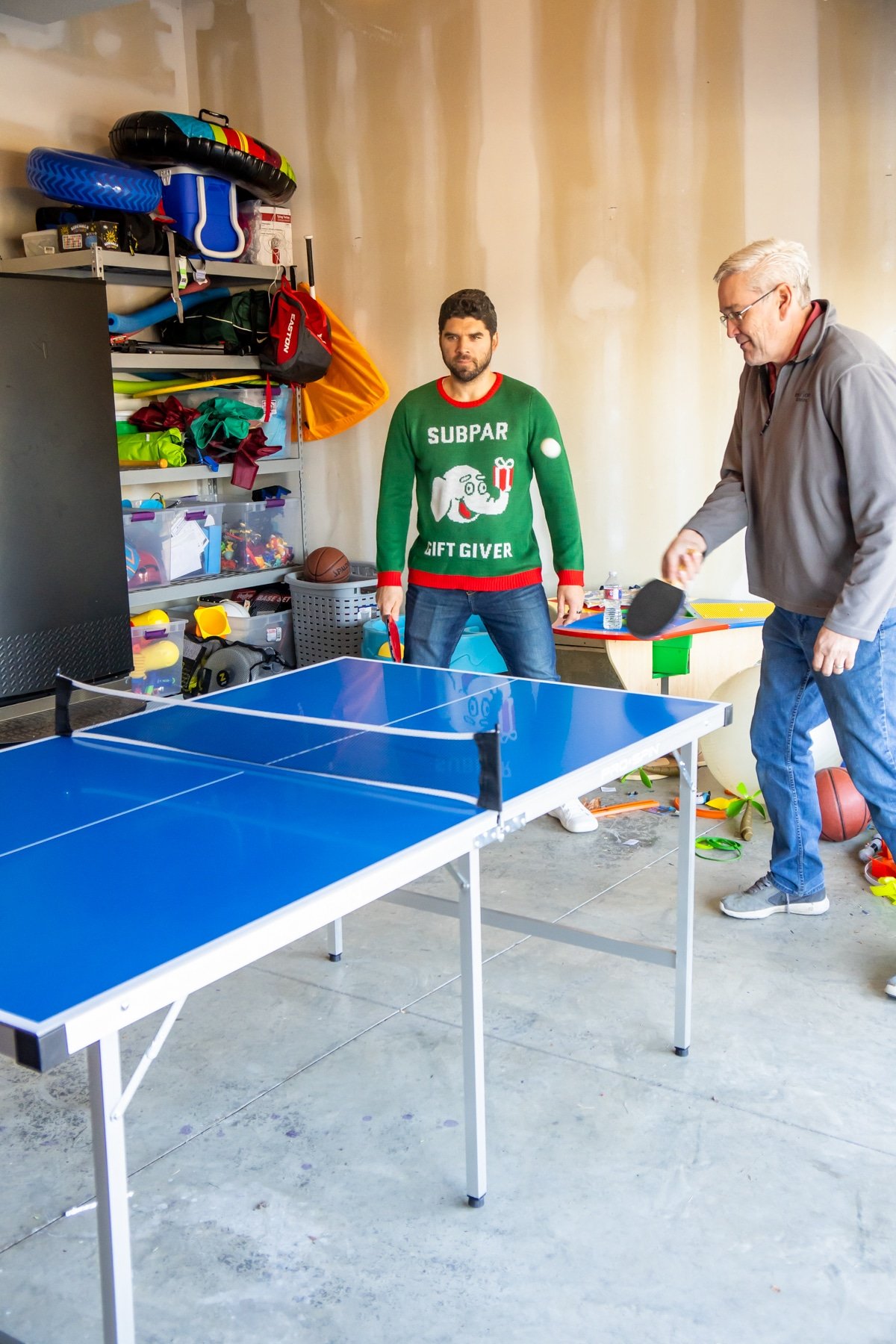 Partners playing ping pong games in a garage