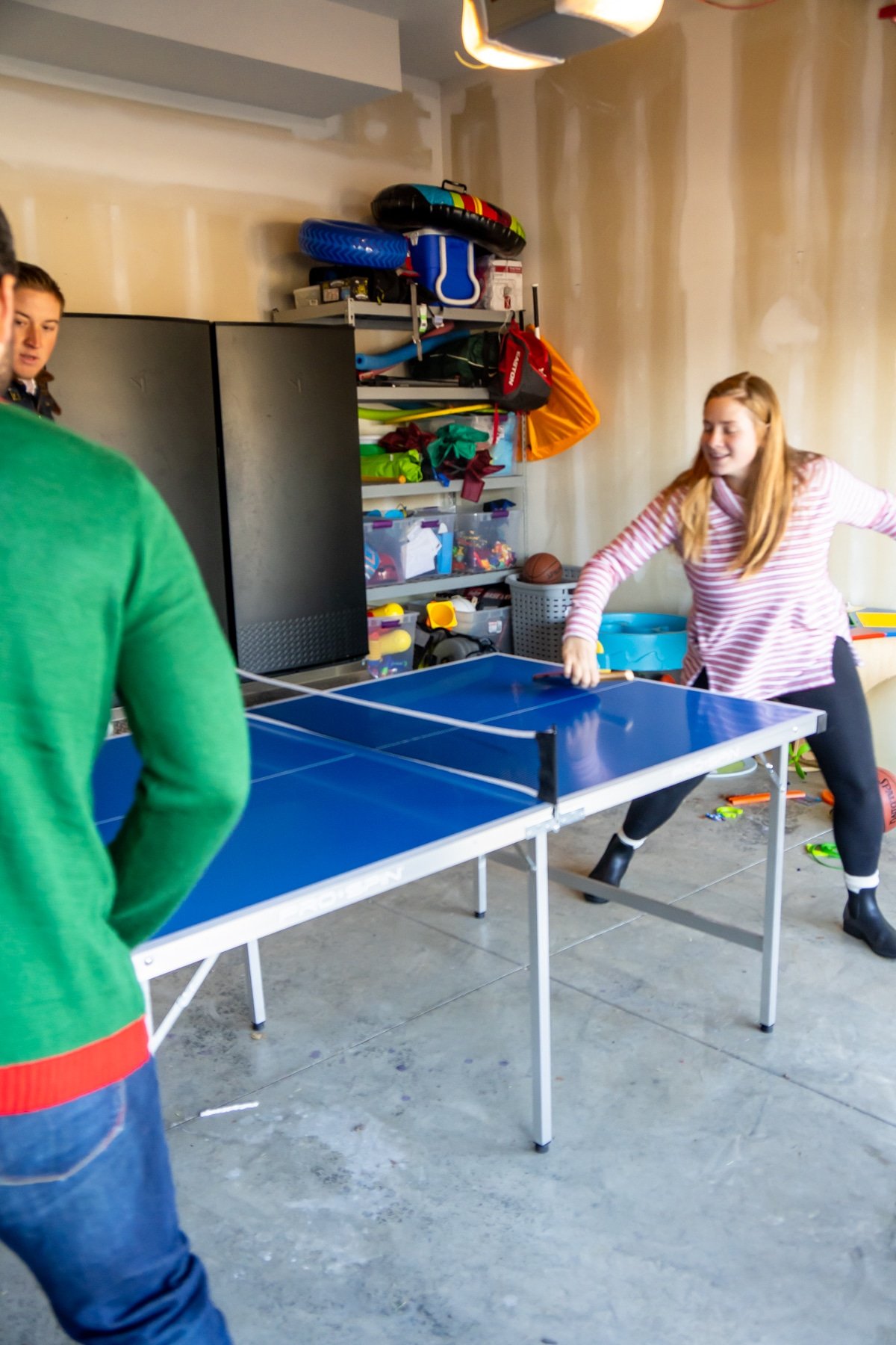 Family standing around a ping pong table