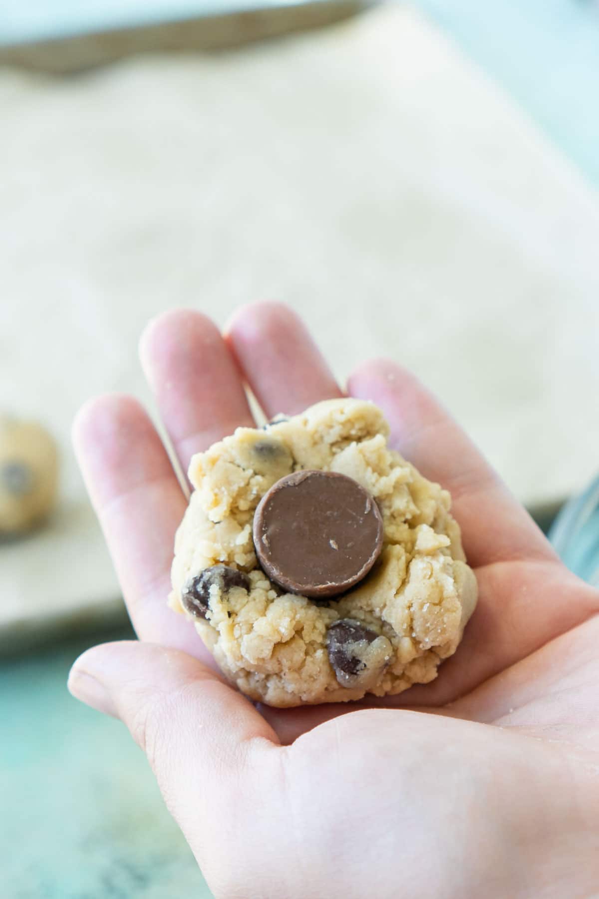 Woman's hand adding a rolo into the center of a rolo cookie