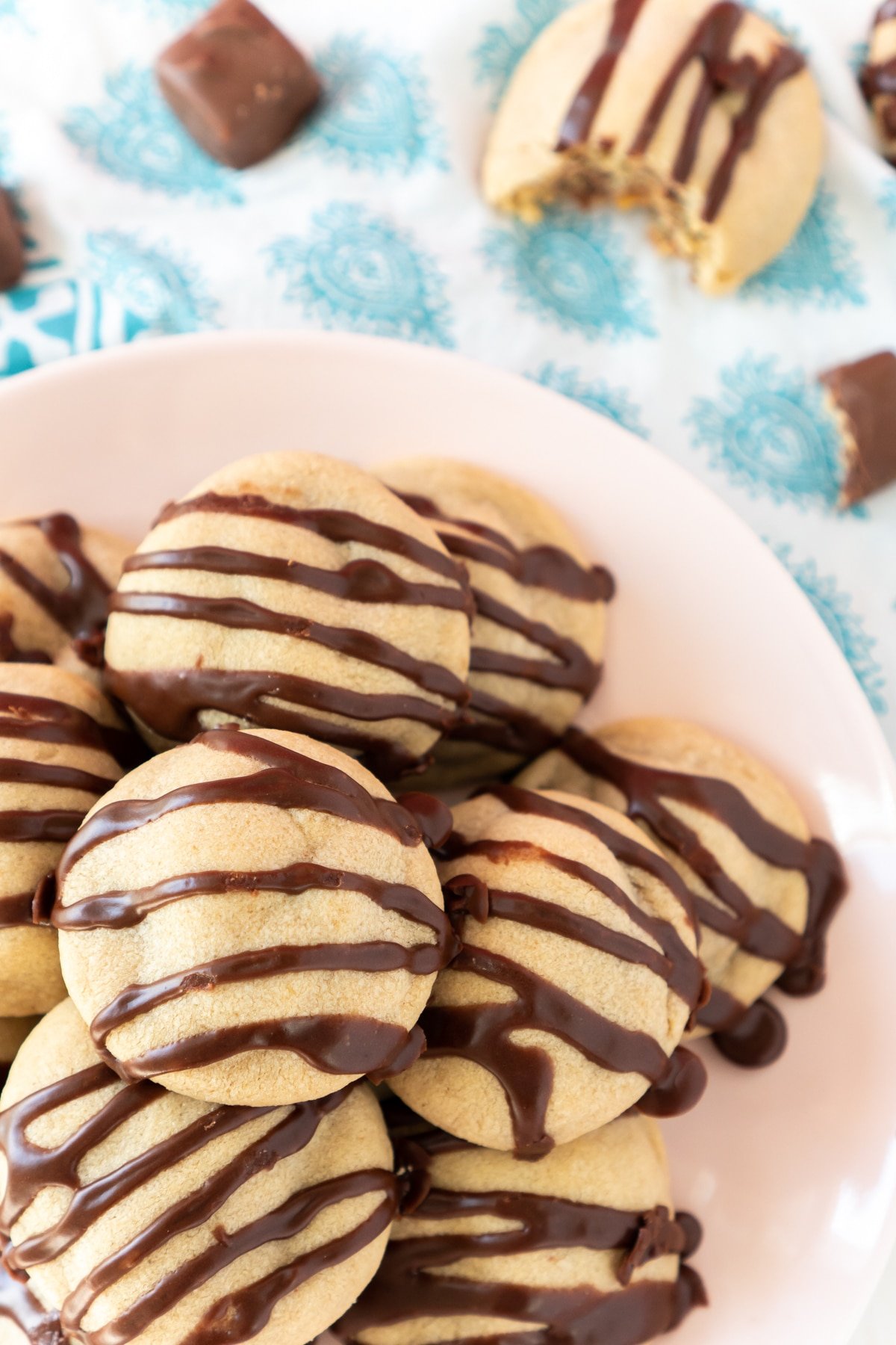 Plate of snickers cookies with chocolate drizzled on them