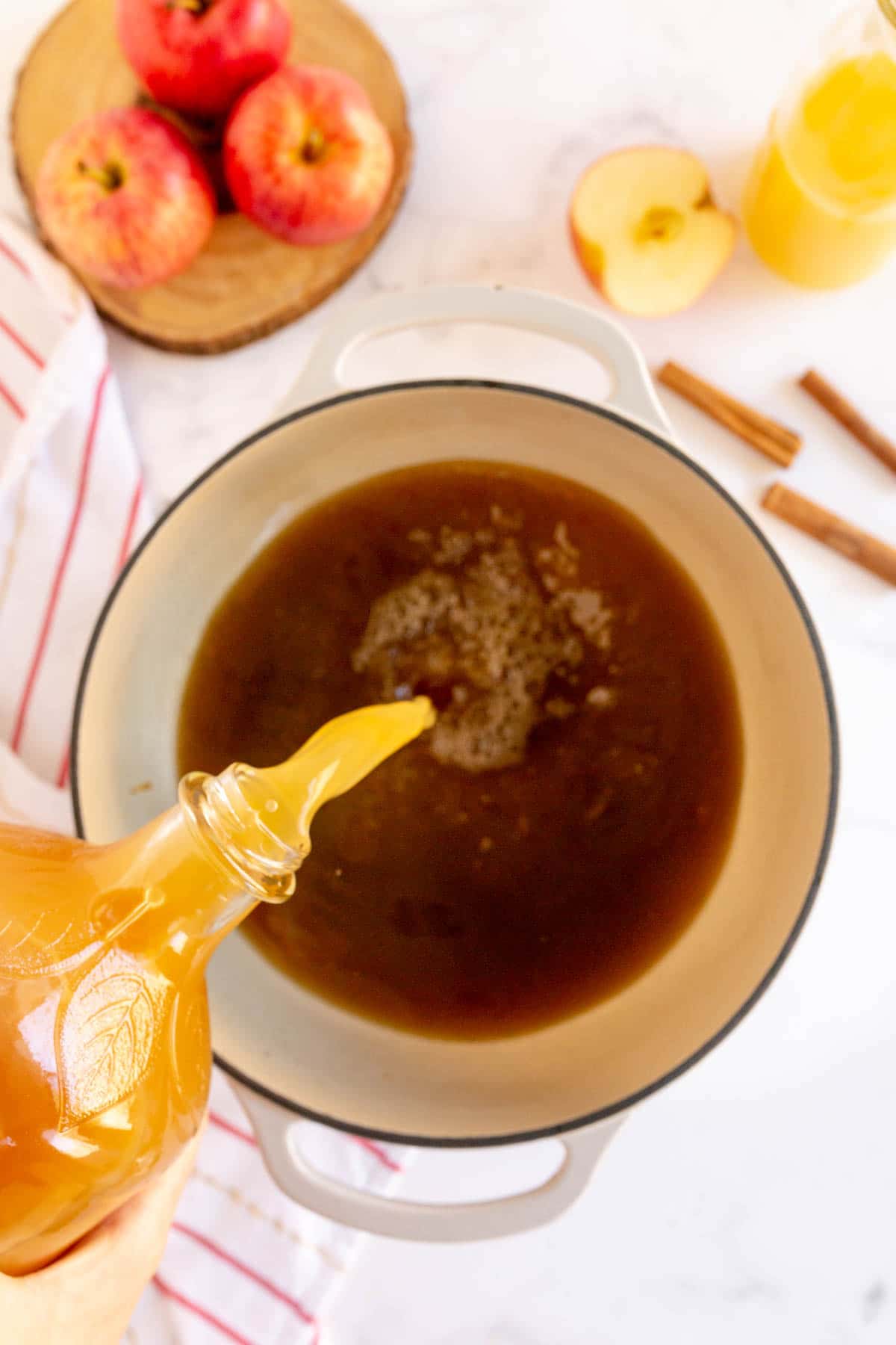 Woman pouring apple cider into a pot