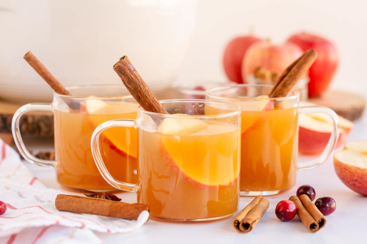 Horizontal image of three glasses of spiced apple cider