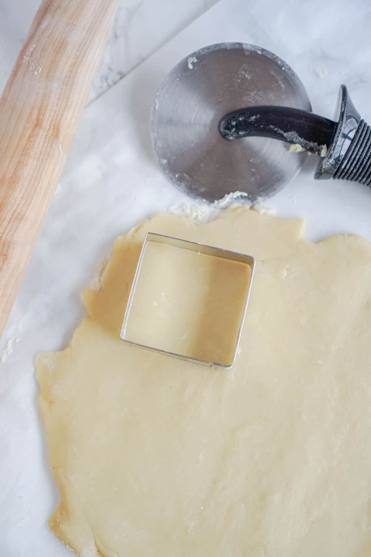 Sugar cookie dough with a square cookie cutter