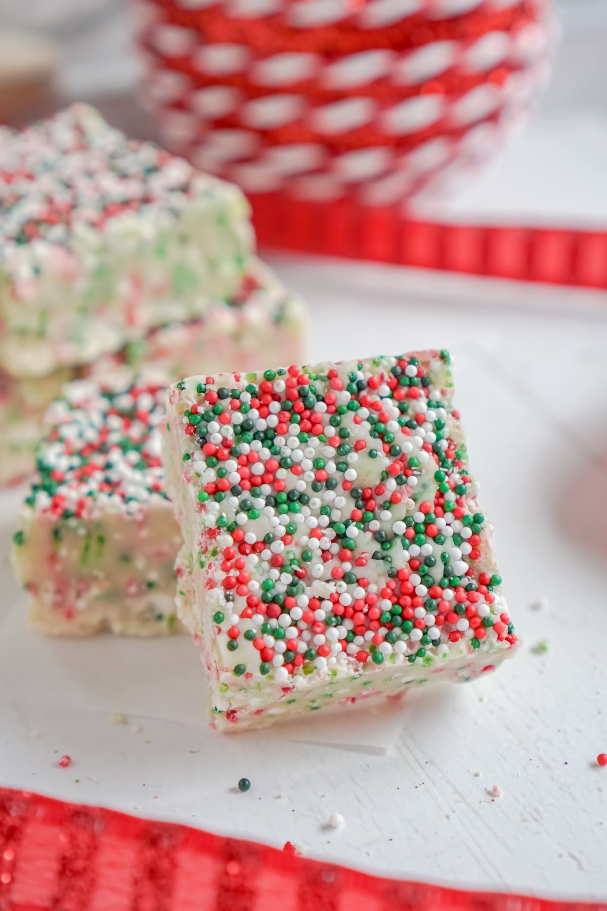 Piece of white chocolate fudge with red ribbon in the background