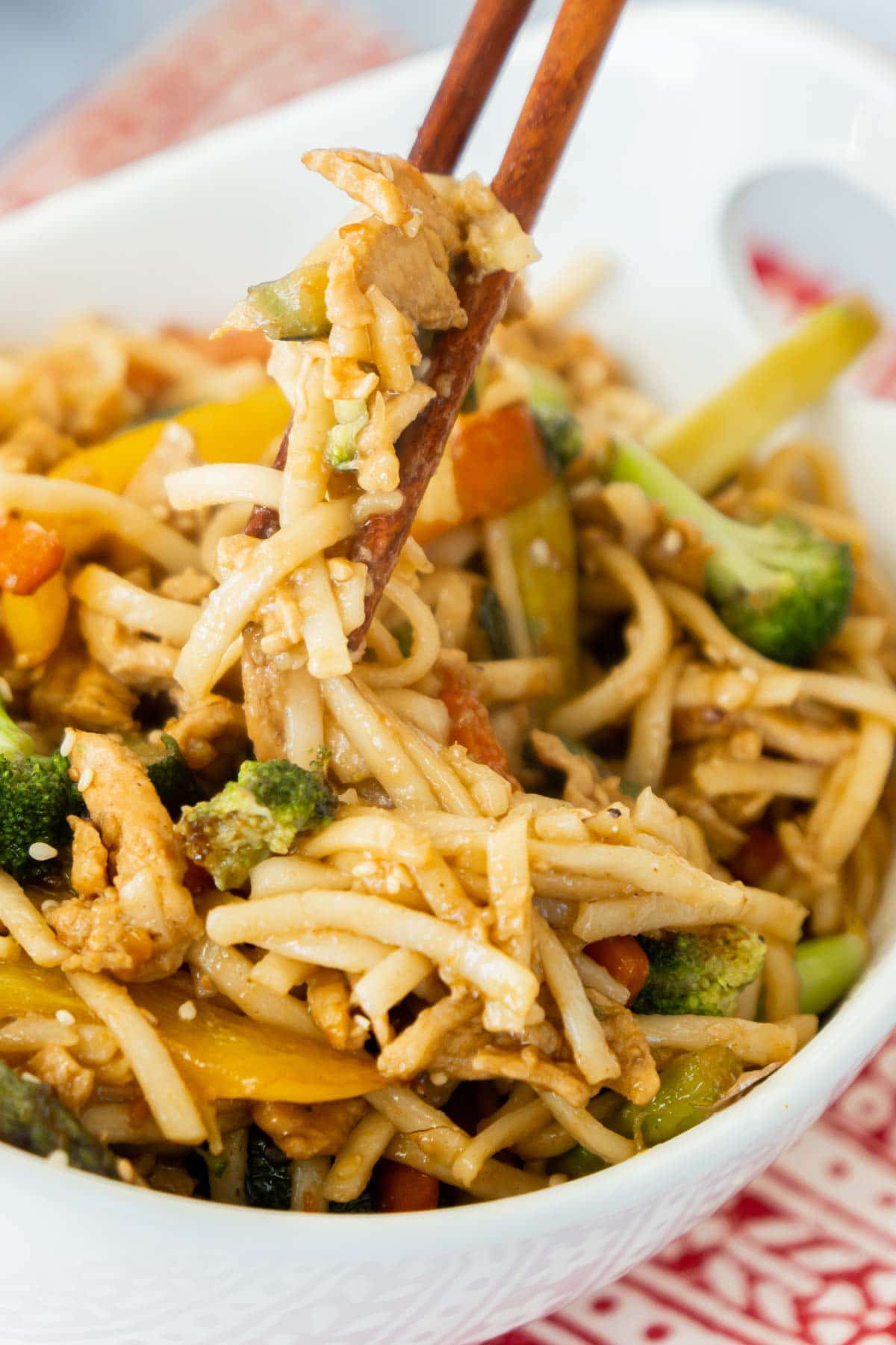 White bowl of teriyaki stir fry with a pair of chopsticks