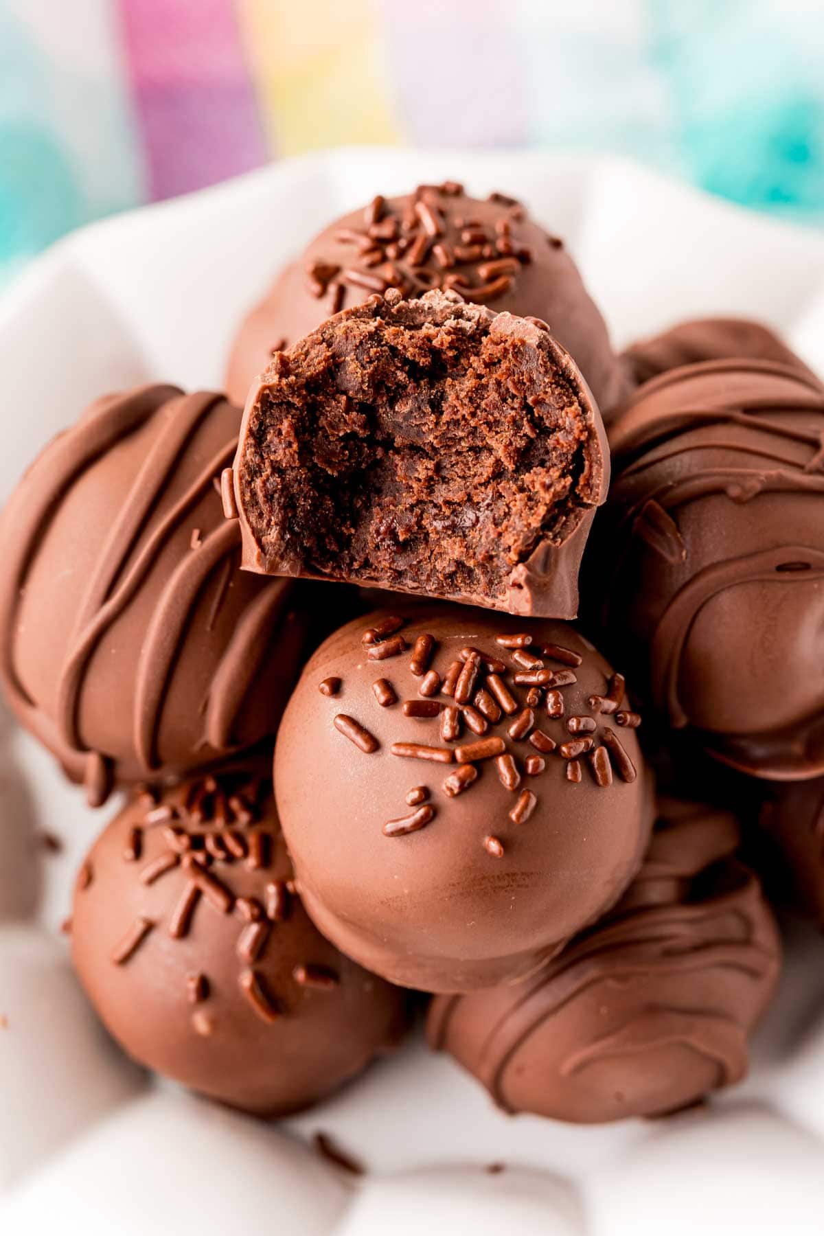 A white plate with a pile of brownie balls on it