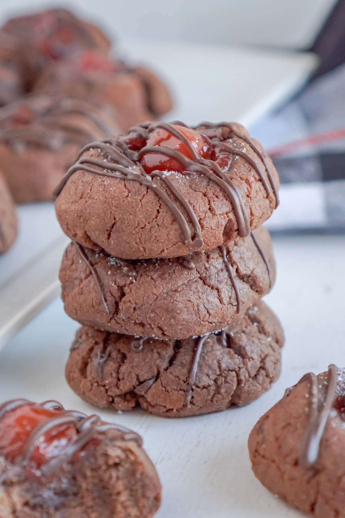Stack of chocolate thumbprint cookies with cherries
