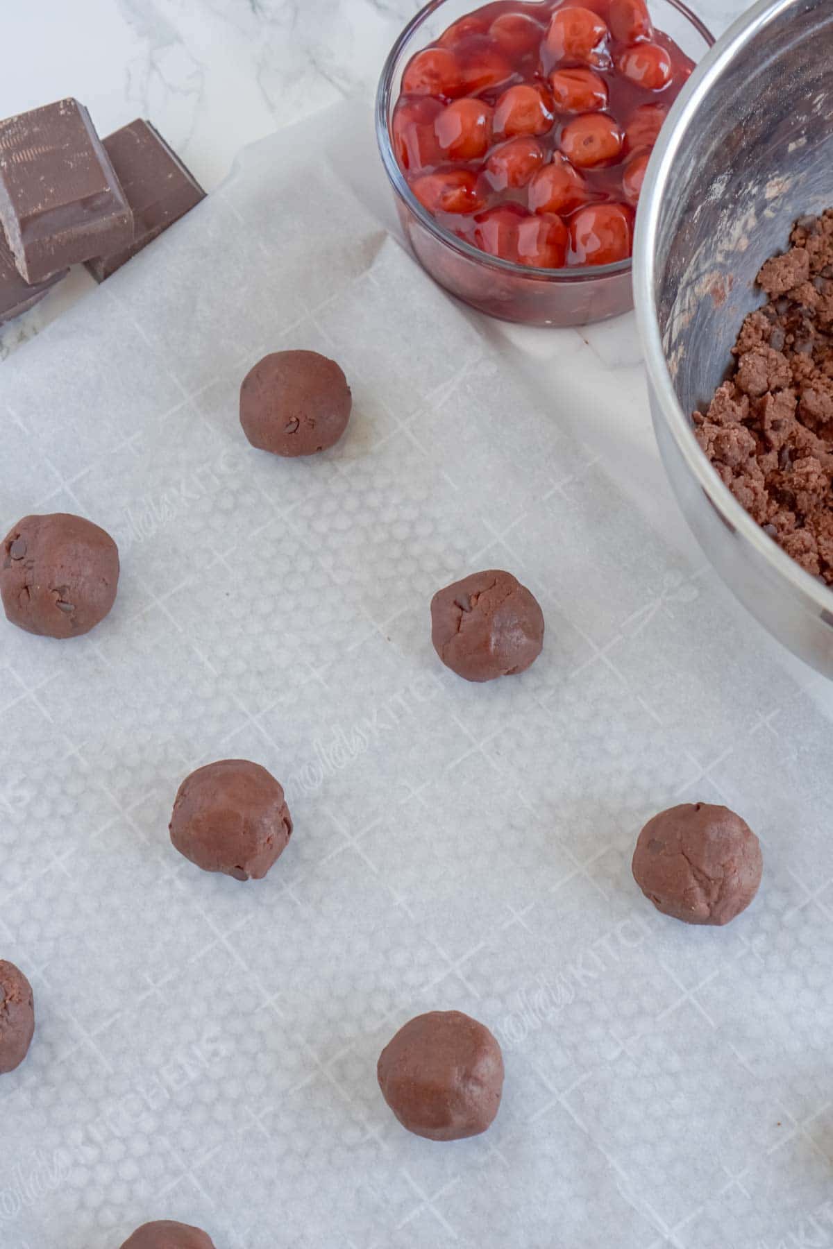 balls of chocolate thumbprint dough on a baking sheet