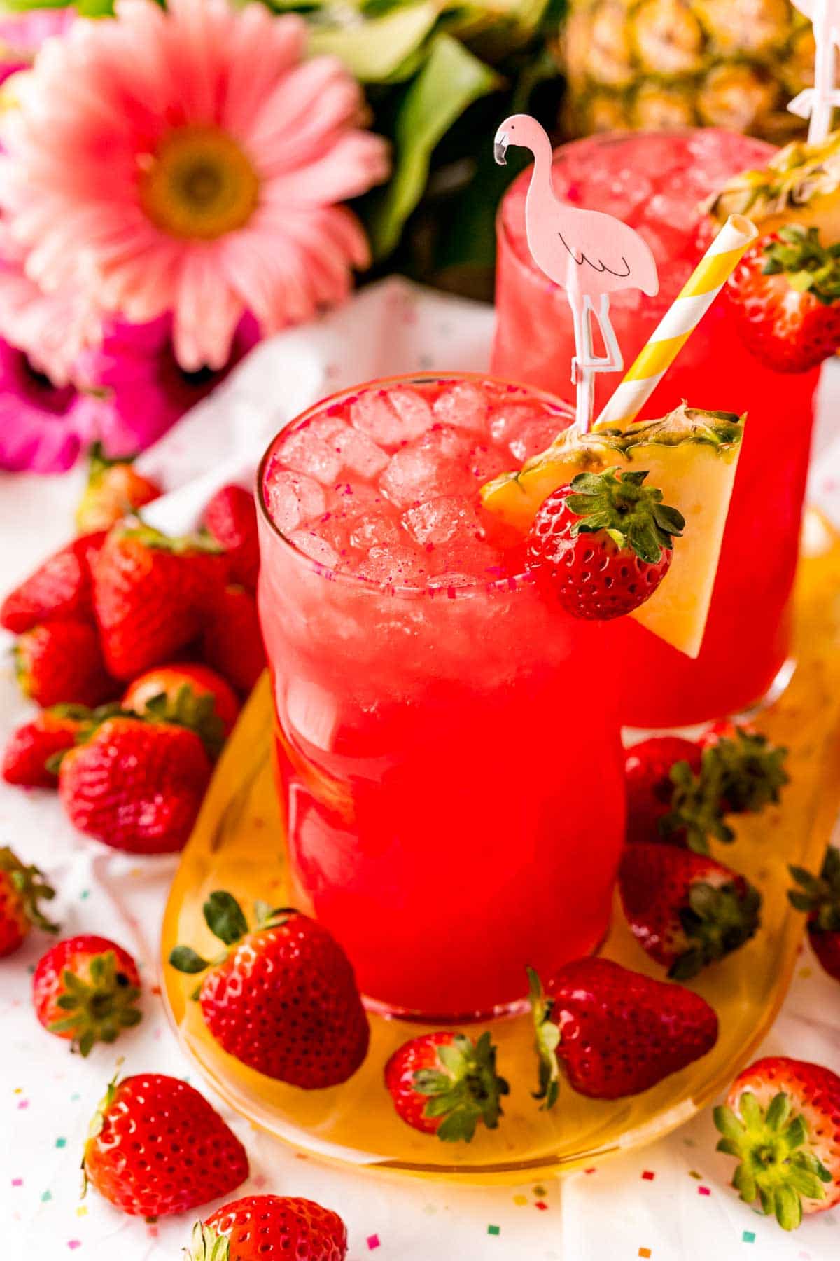 Strawberry cotton candy drink surrounded by flowers and fruit