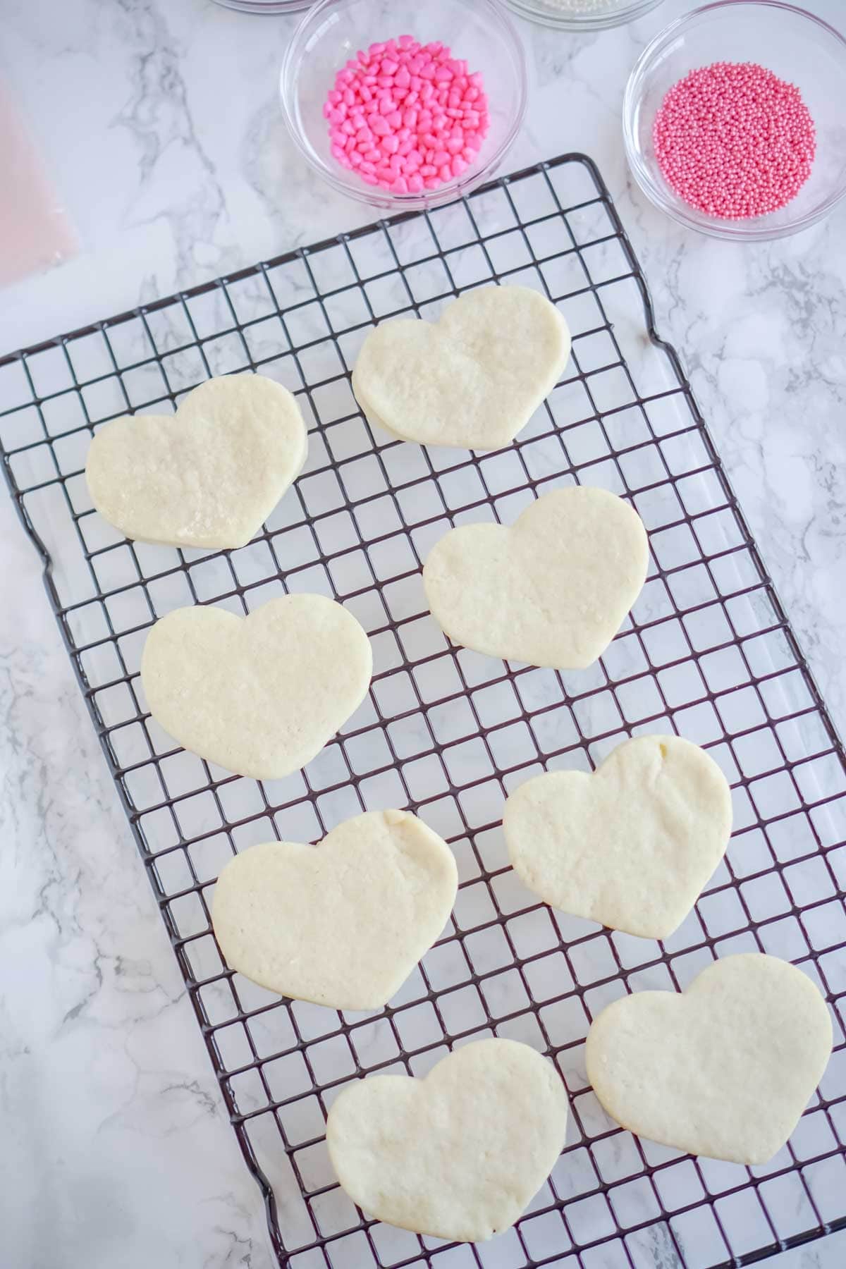 Heart shaped cream cheese sugar cookies on a cooling rack