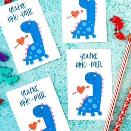Four dinosaur valentines on a blue background