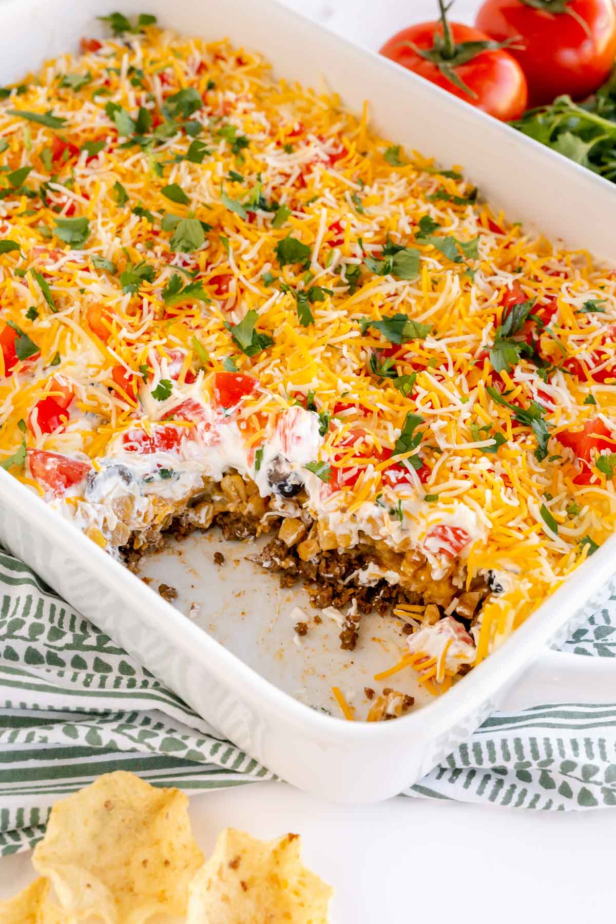 layered taco dip in a white baking dish