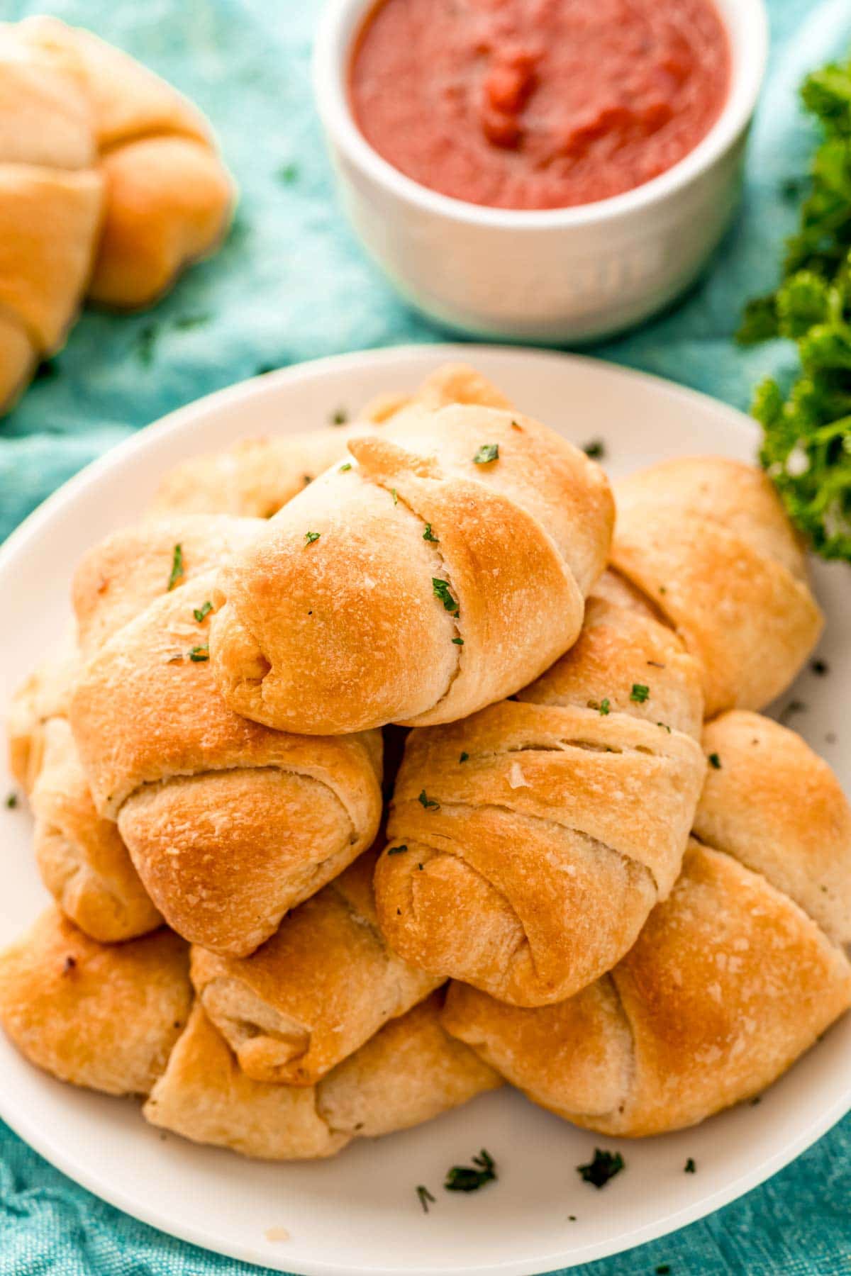 Pile of pizza roll ups on a white plate