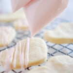 Bag of sugar cookie icing being piped onto cookies