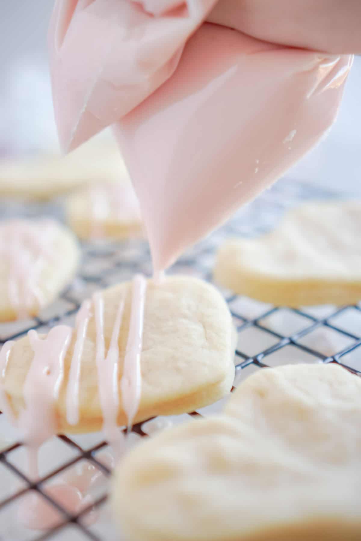 Bag of sugar cookie icing being piped onto cookies