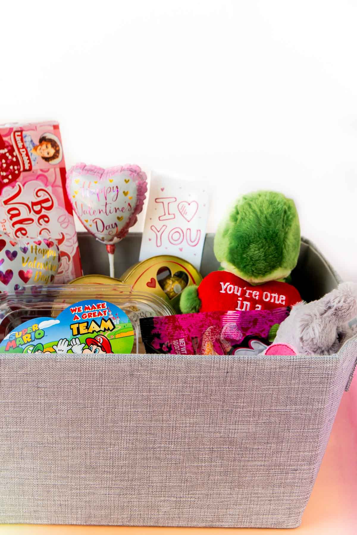 Gray gift basket with stuffed animals coming out