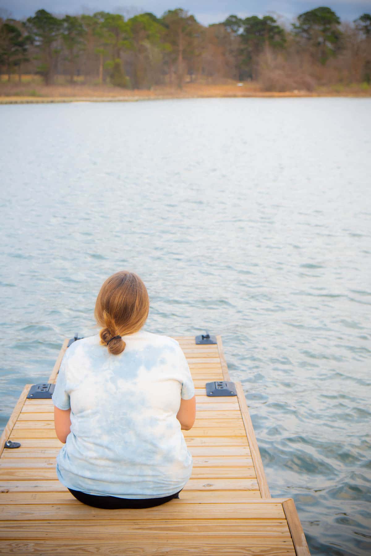 Woman sitting on a dock at Margaritaville Lake Conroe