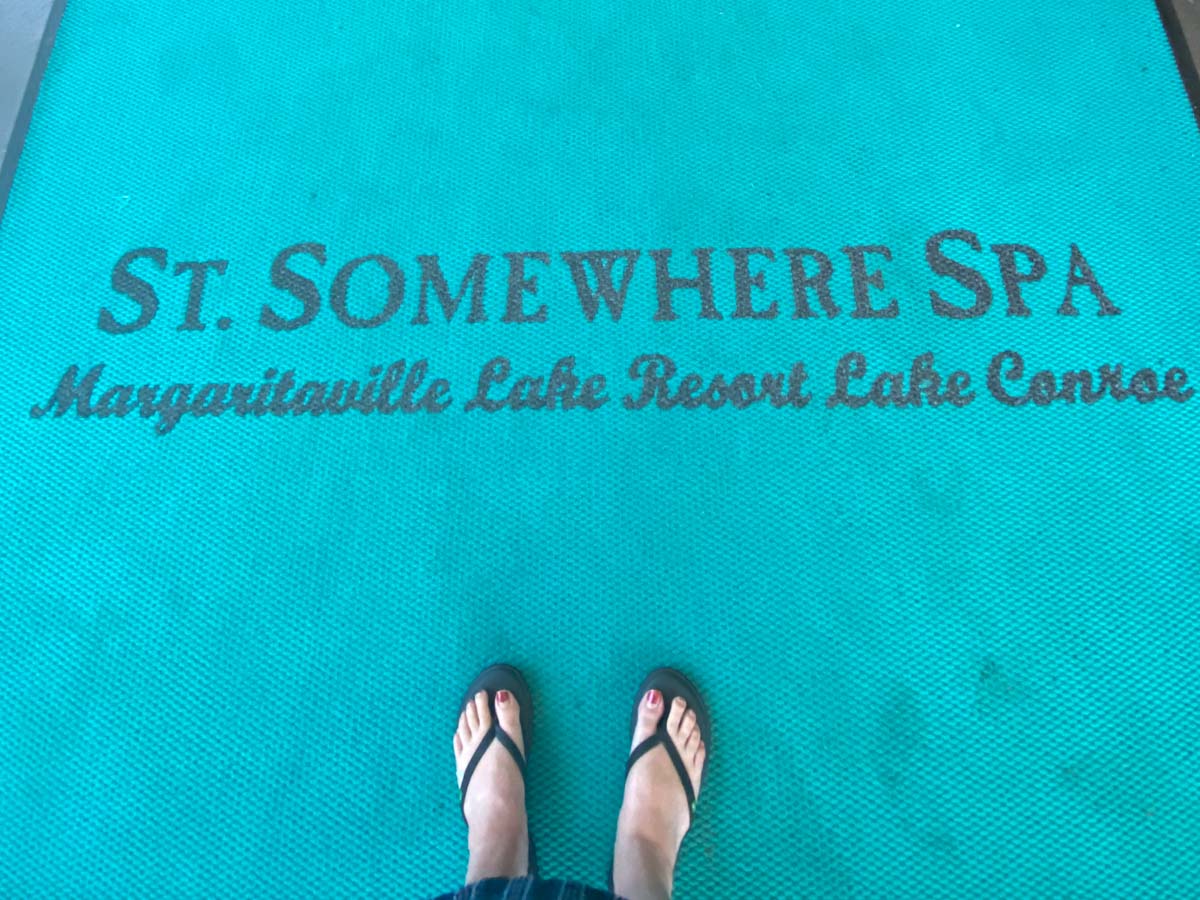 Womans' feet on a blue st somewhere spa entry mat