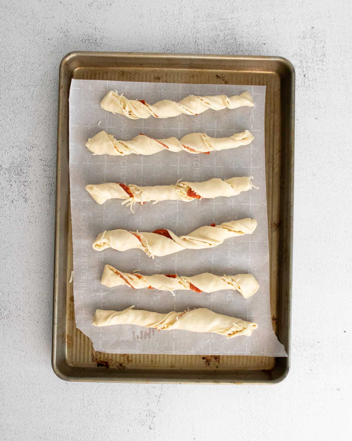 Baking sheet with unbaked pizza twists
