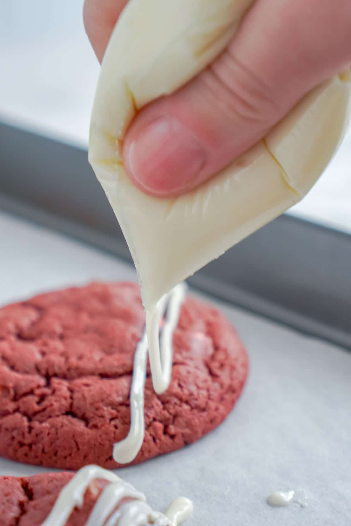 Piping icing over red velvet cookies