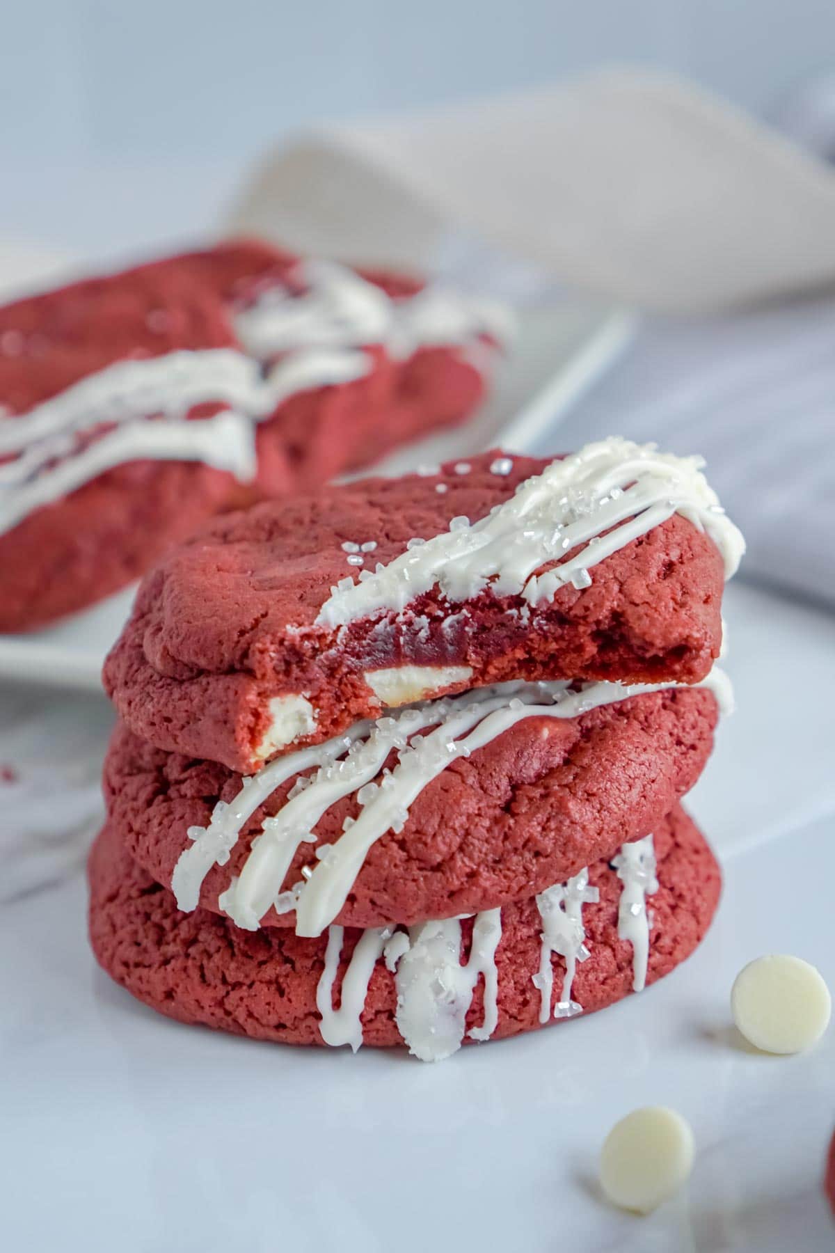 Stack of three red velvet cookies with icing