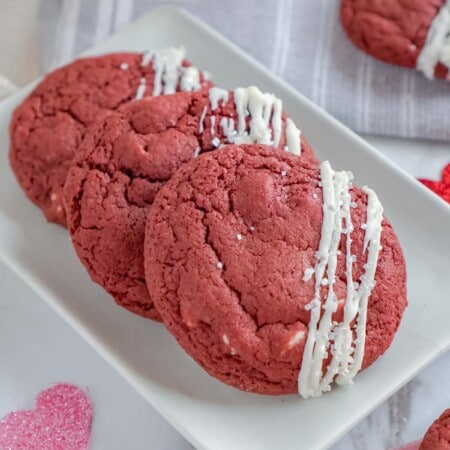 White plate with three red velvet cookies and hearts all around