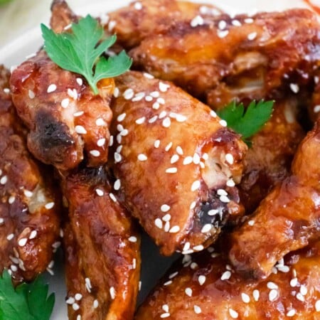 Close up image of sticky chicken wings with parsley