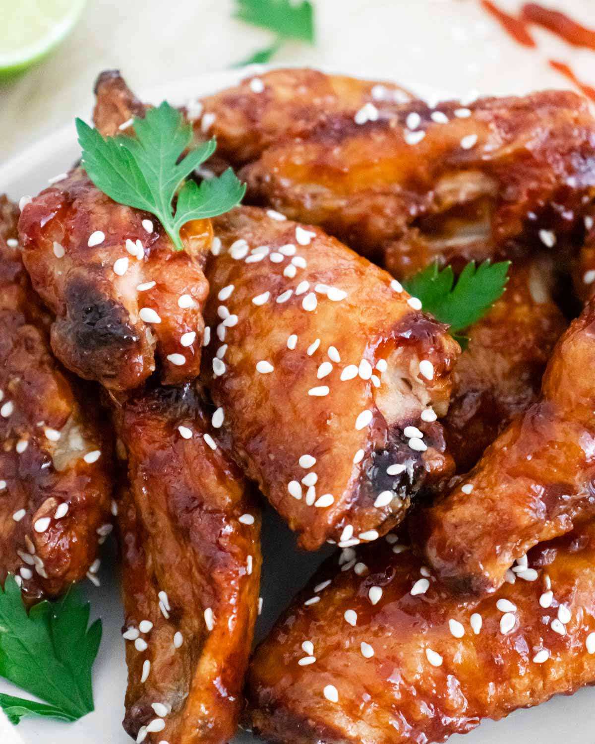 Close up image of sticky chicken wings with parsley