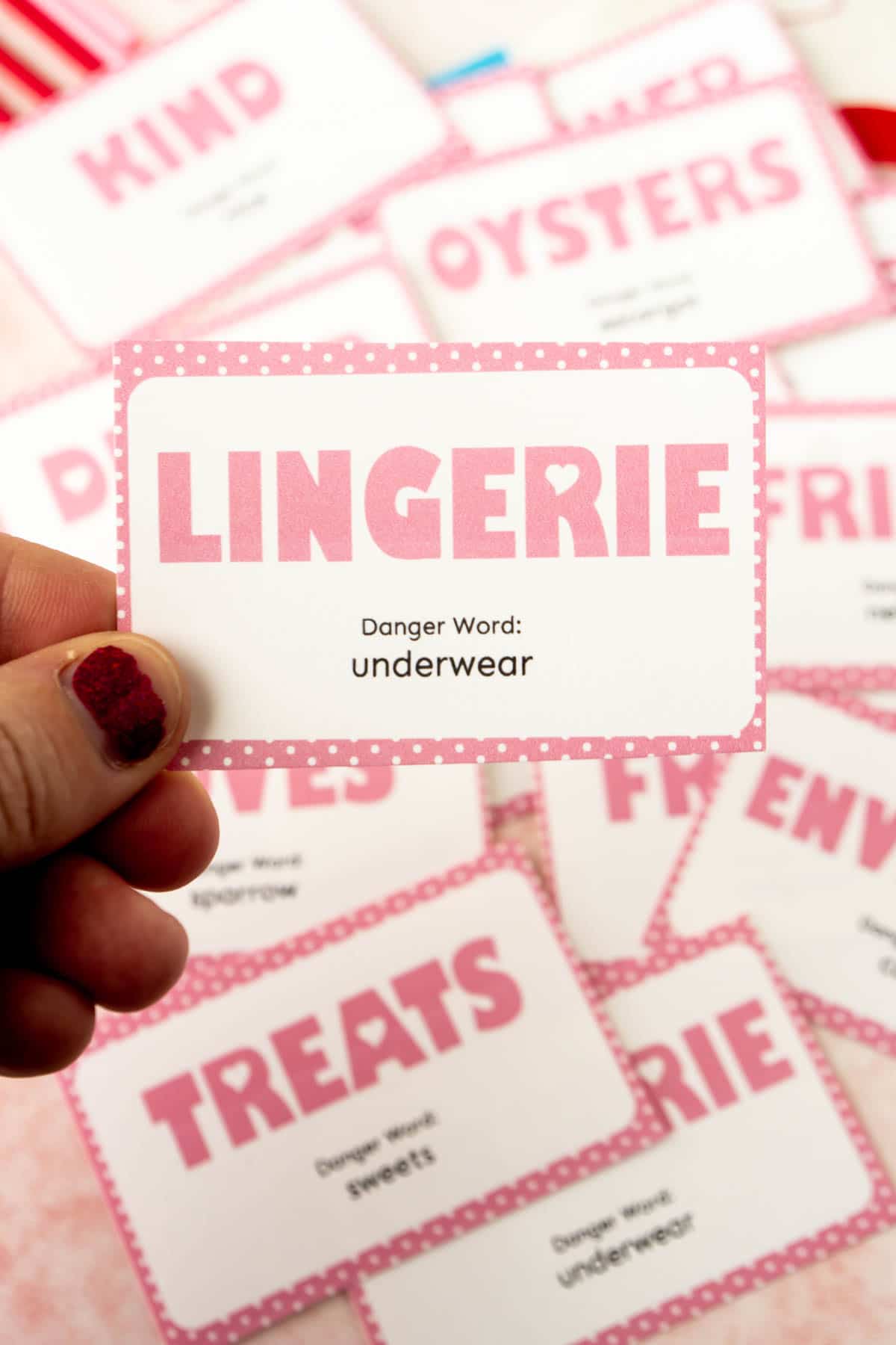 woman's hand holding a lingerie danger word card