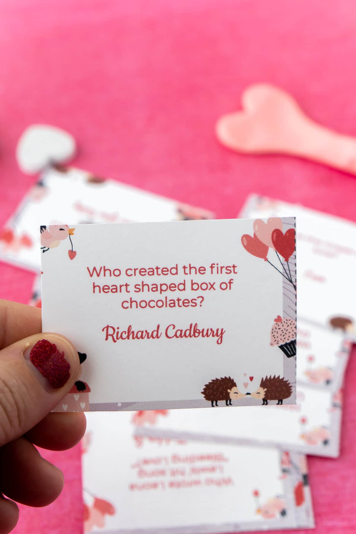 Woman's hand holding a Valentines trivia card