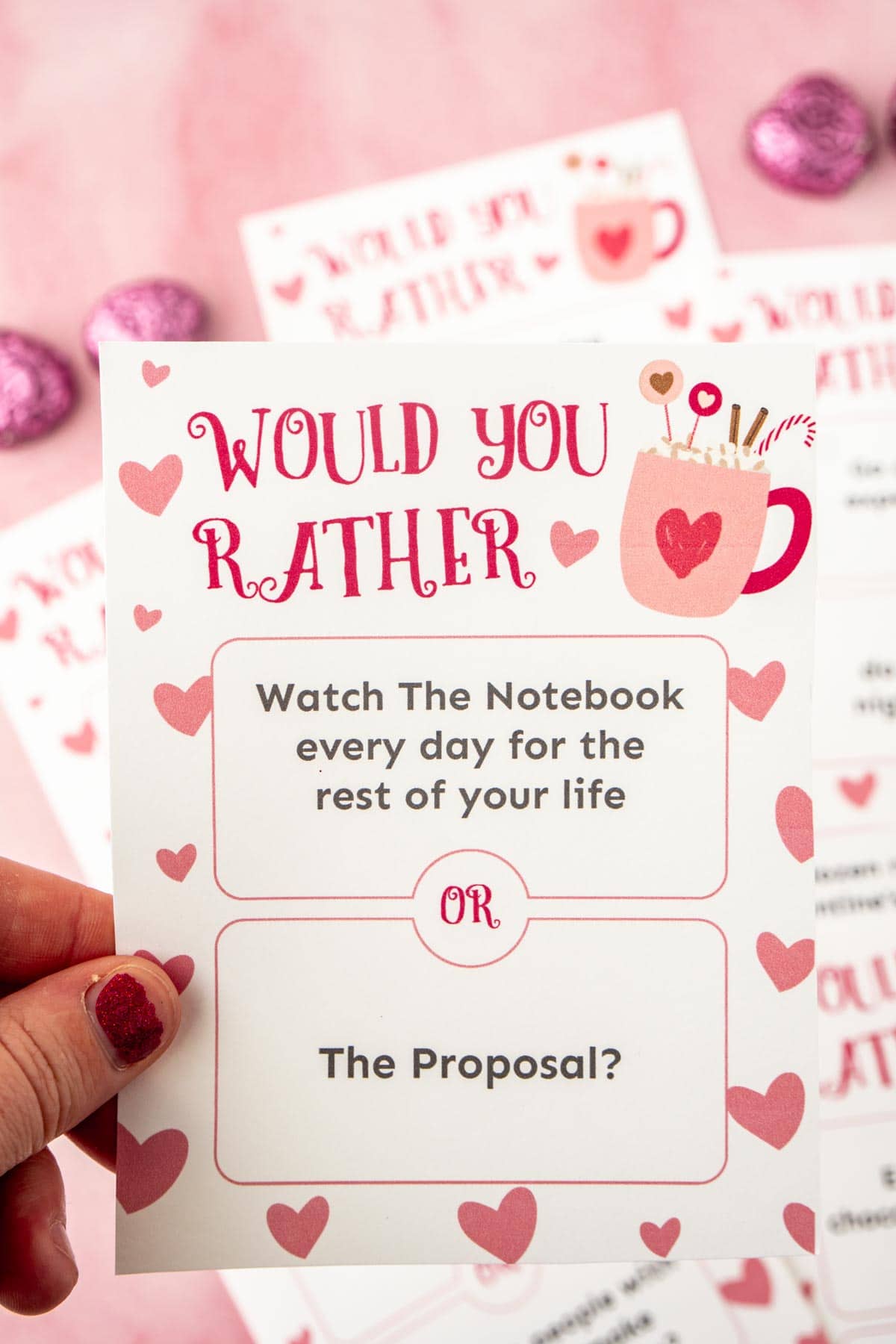 woman's hand holding a Valentine's Day would you rather card