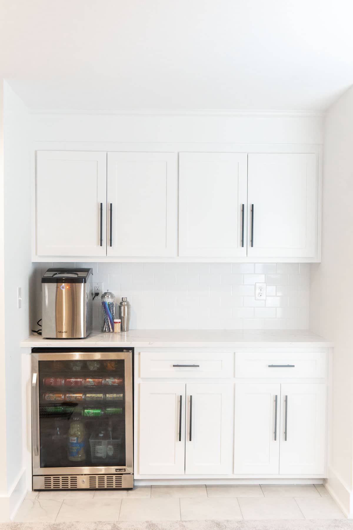 White basement dry bar with a mini fridge