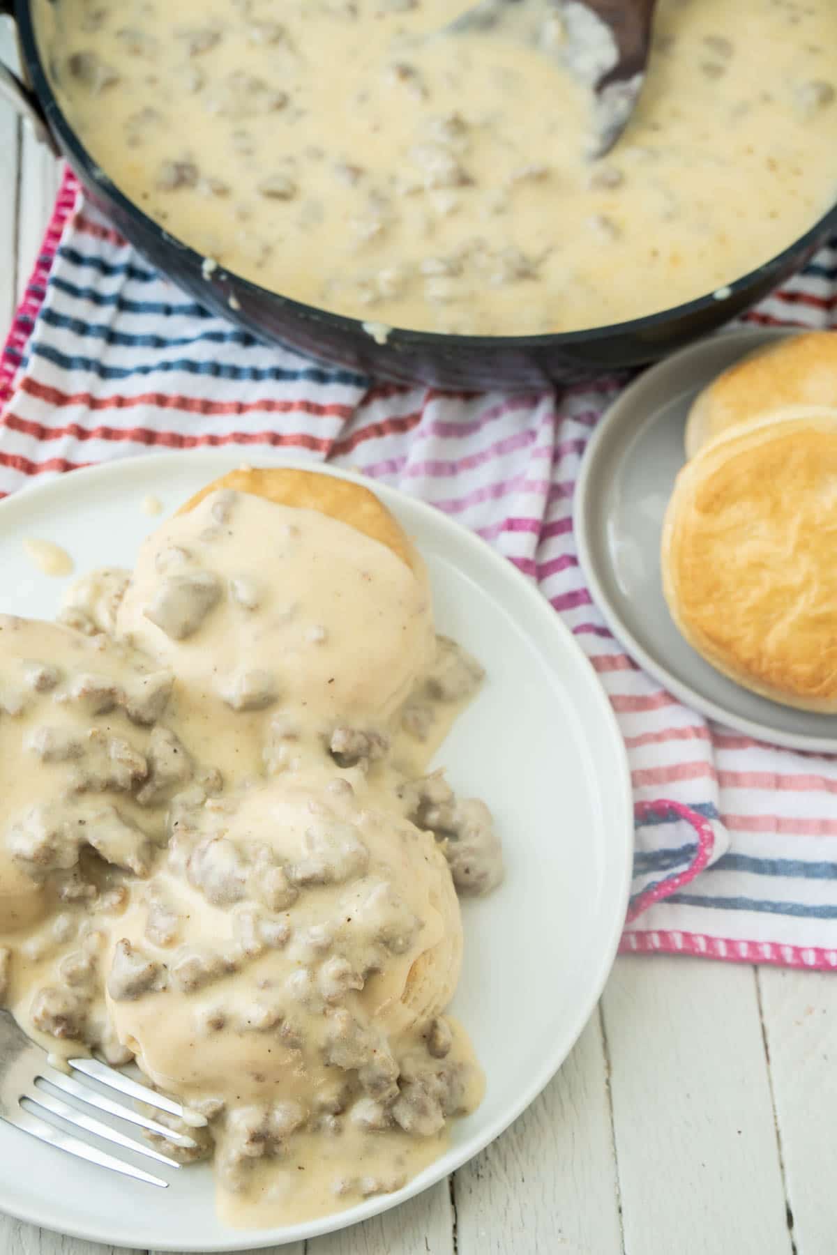 Biscuits and sausage gravy on a white plate