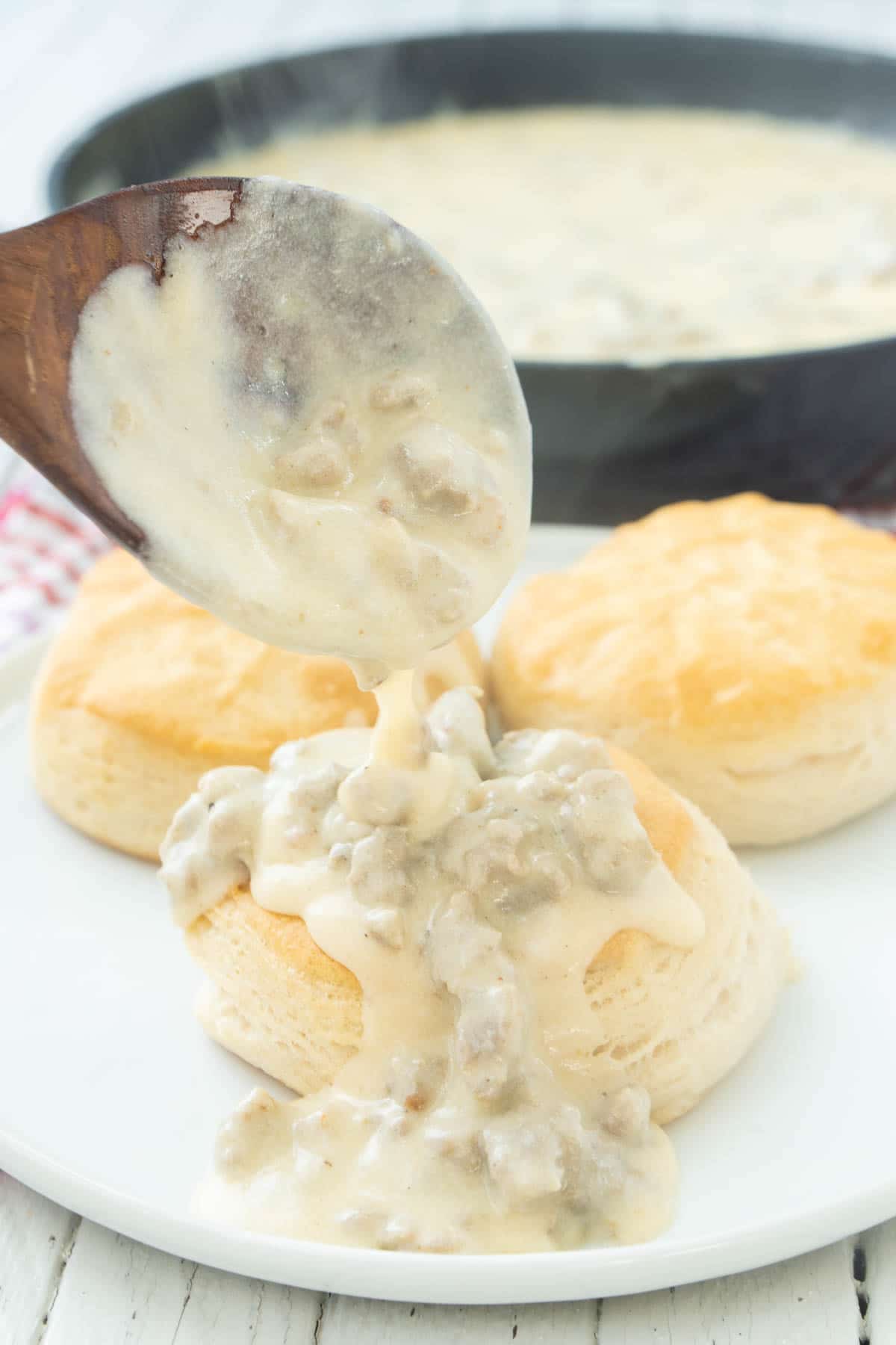 Spooning sausage gravy over biscuits