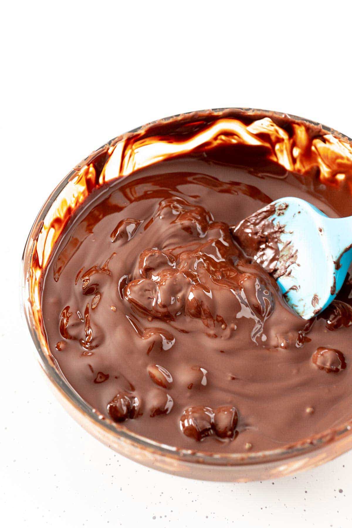 Rubber spatula stirring a bowl of melted chocolate