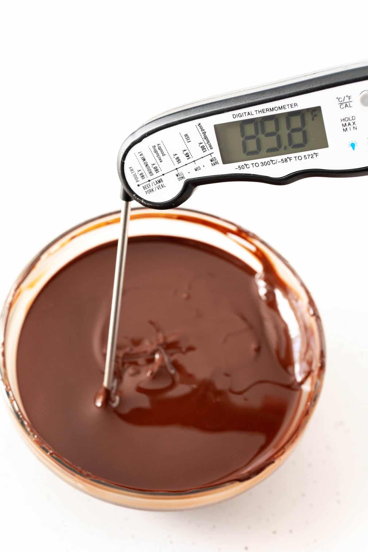 Melted chocolate in a glass bowl with a thermomter