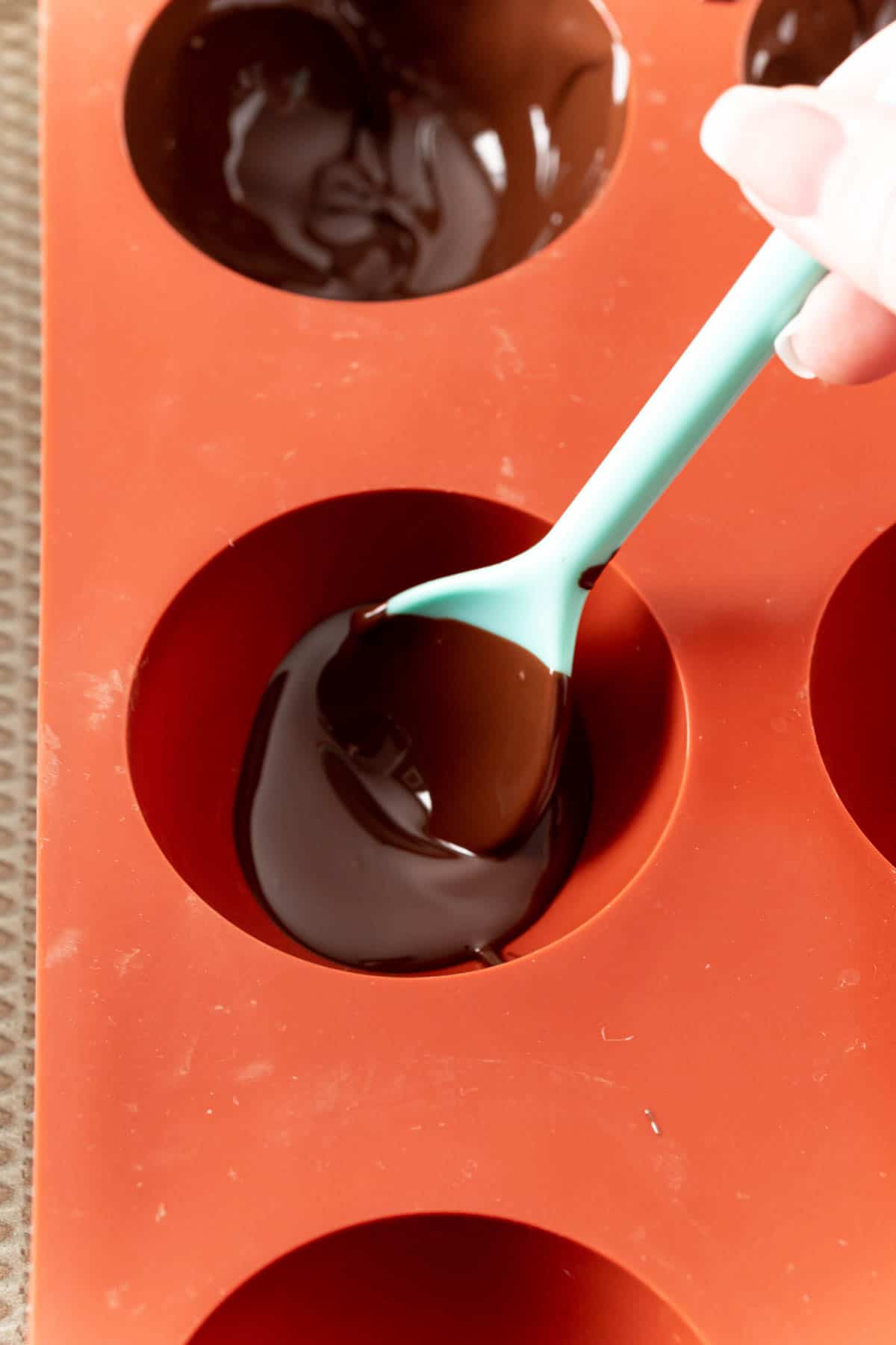 Spoon of chocolate being put into silicone molds