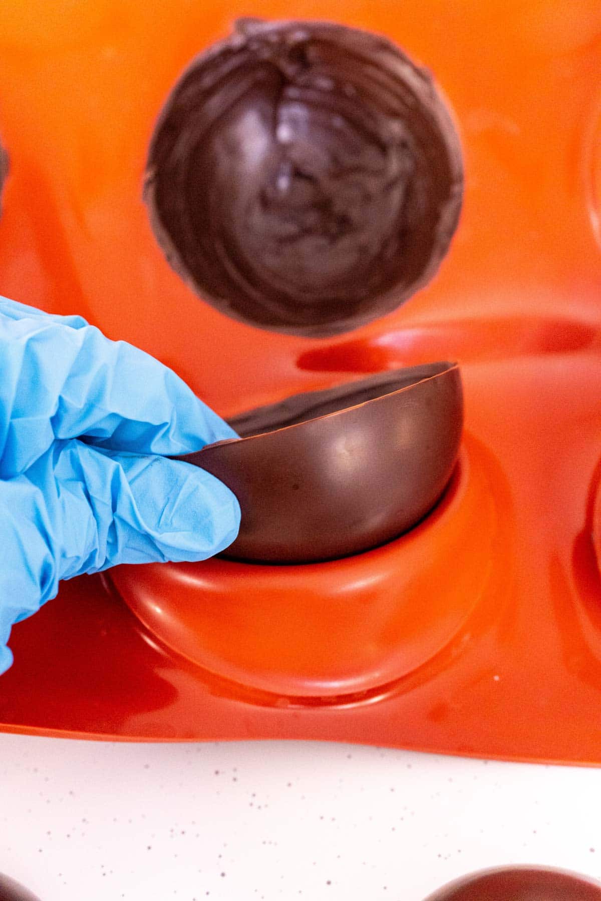 Woman's hand removing a hot chocolate bomb from a mold