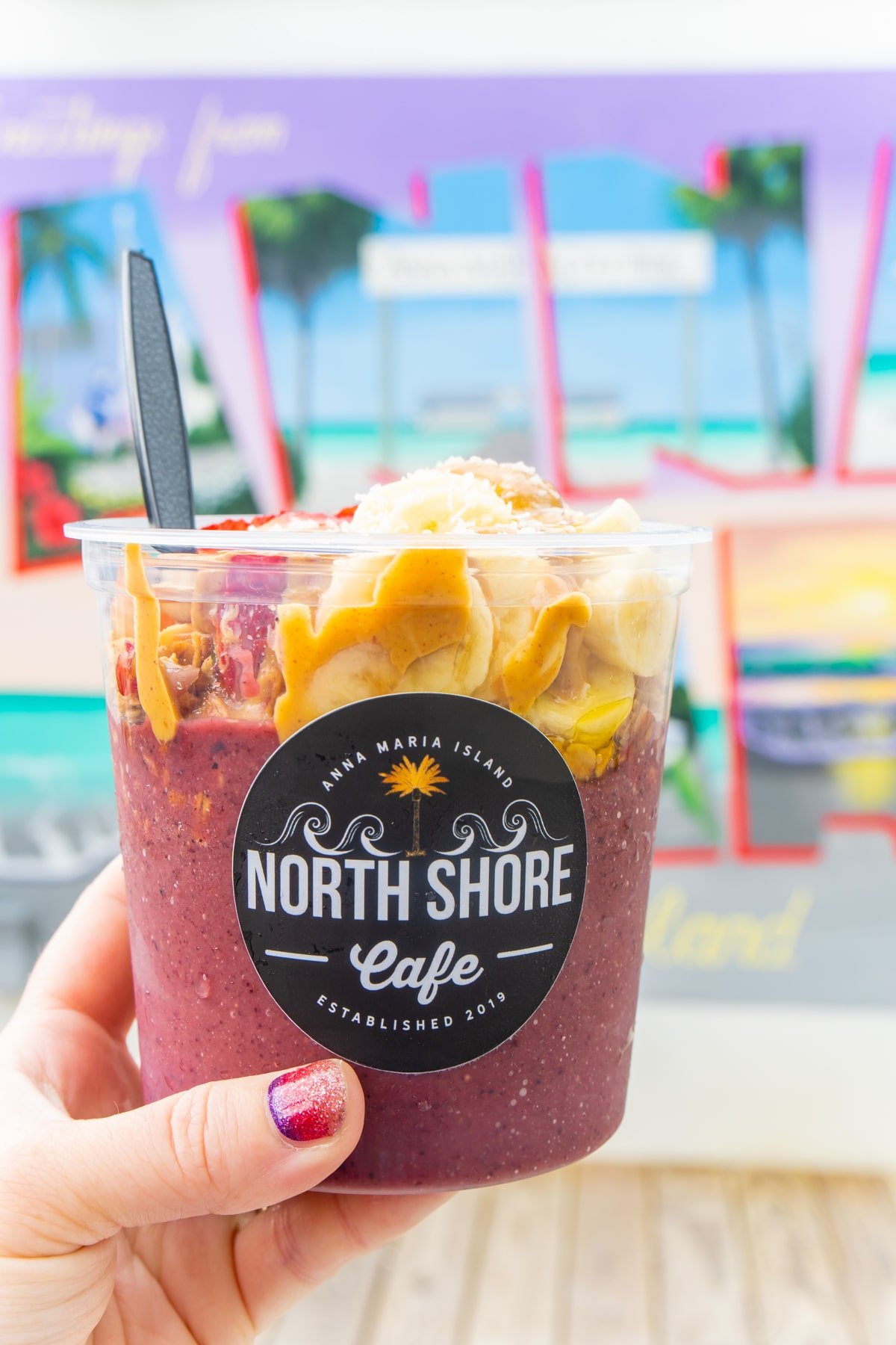 Acai bowl being held by a woman's hand